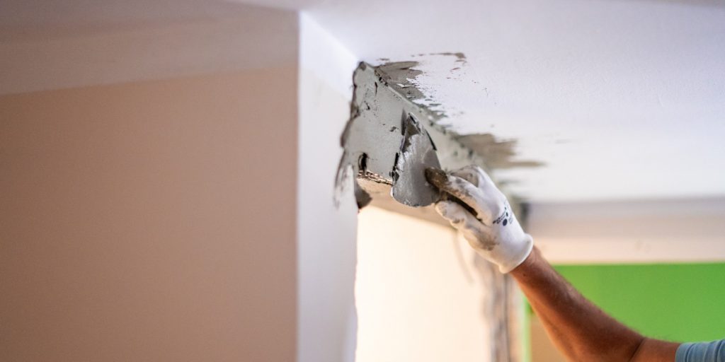 Unrecognizable Senior man Spreading adhesive on the ceiling