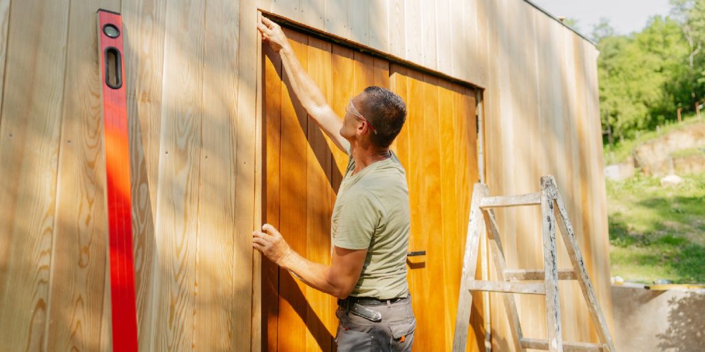 Photo of a man working on a garden house