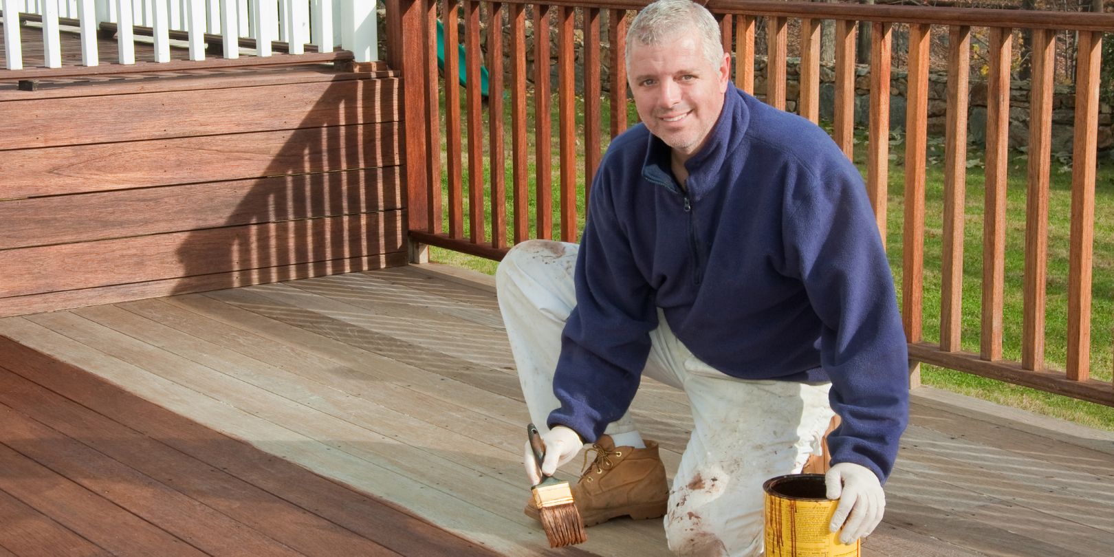 painter or handyman staining a deck