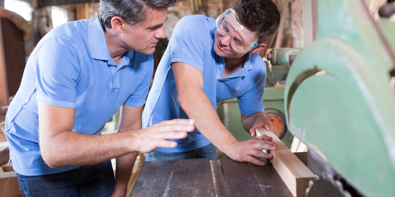 Carpenter Teaching Apprentice How To Use Circular Saw
