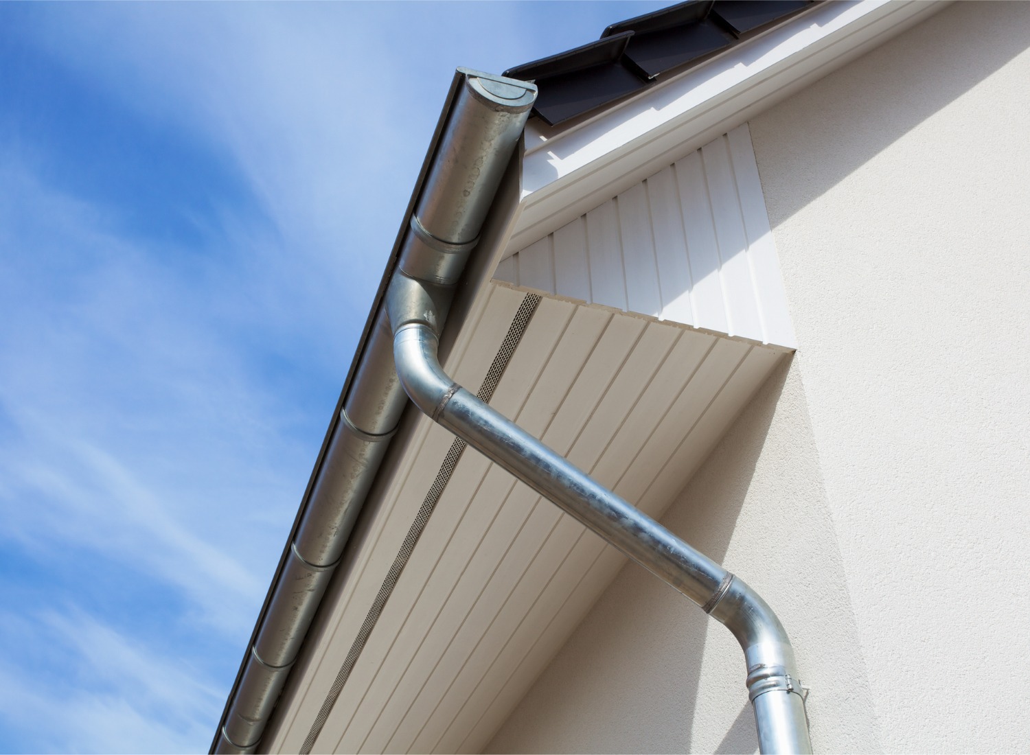 Home's rain gutter with a galvanized steel downspout