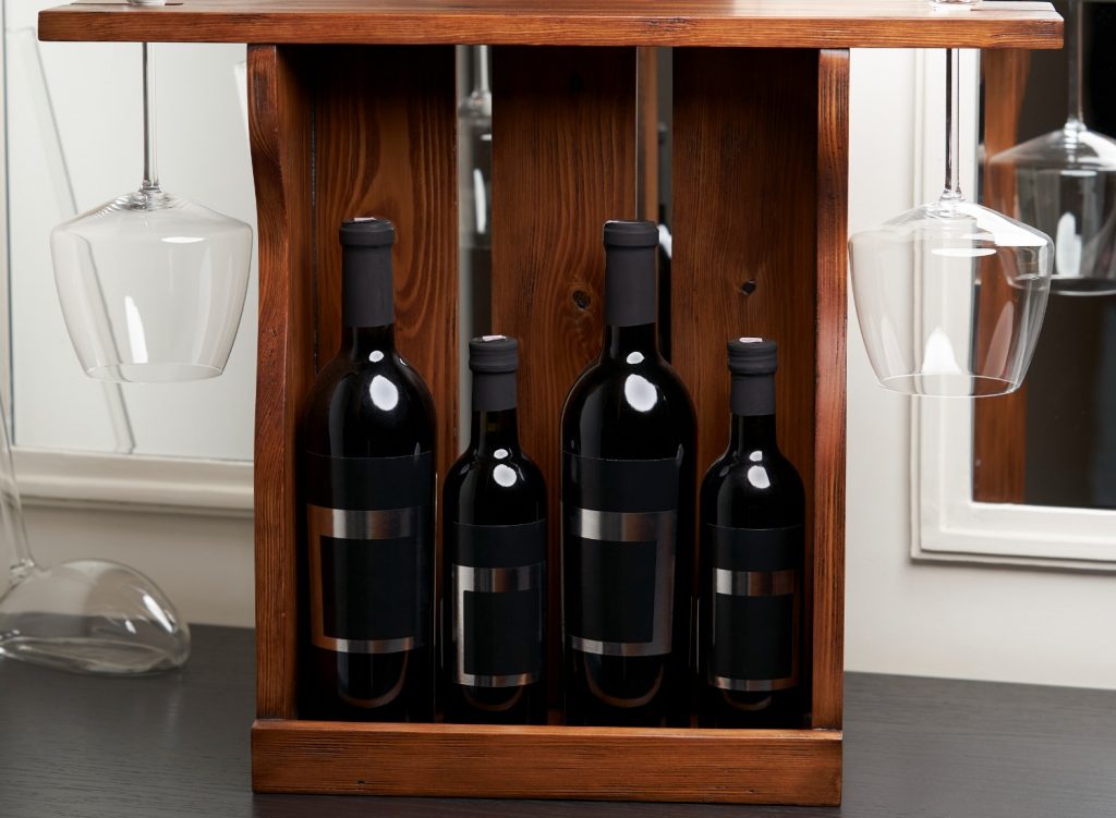 Wine bottles and glasses in a wooden wine rack