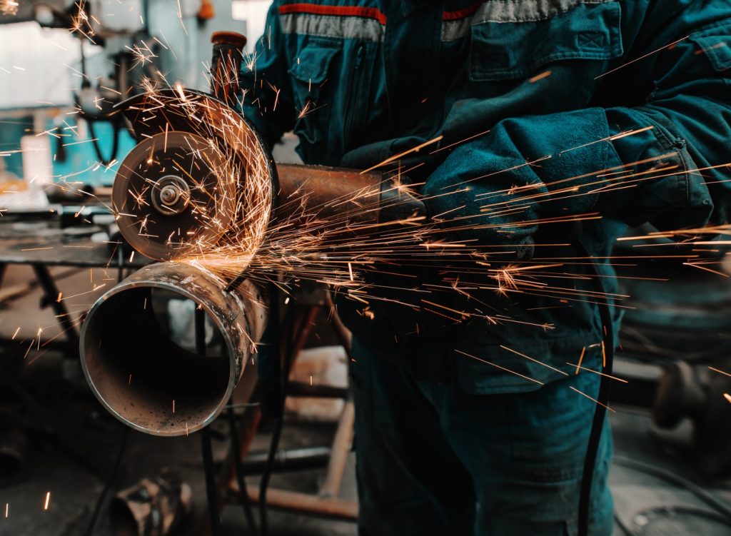 Man cutting a pipe with a grinder