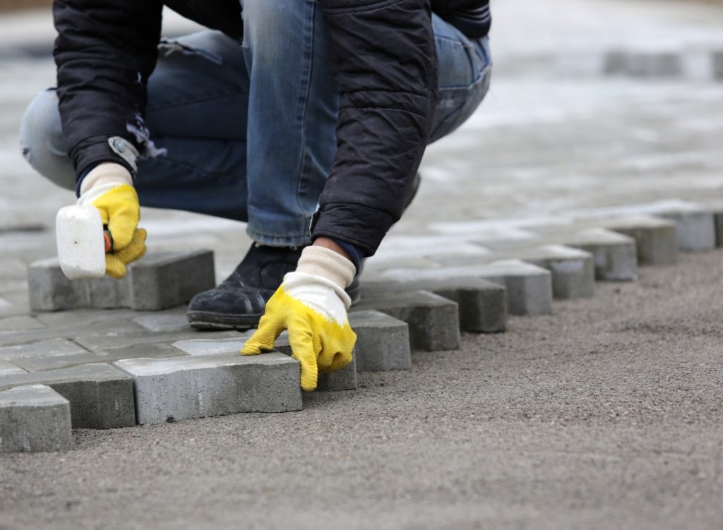 paving-stone-worker.jpg_s=1024×1024&w=is&k=20&c=zU08QzR-WtBM_J_x2Eh4654-DESzmHDQOSlV1q0W6A8= Person laying stone pavers