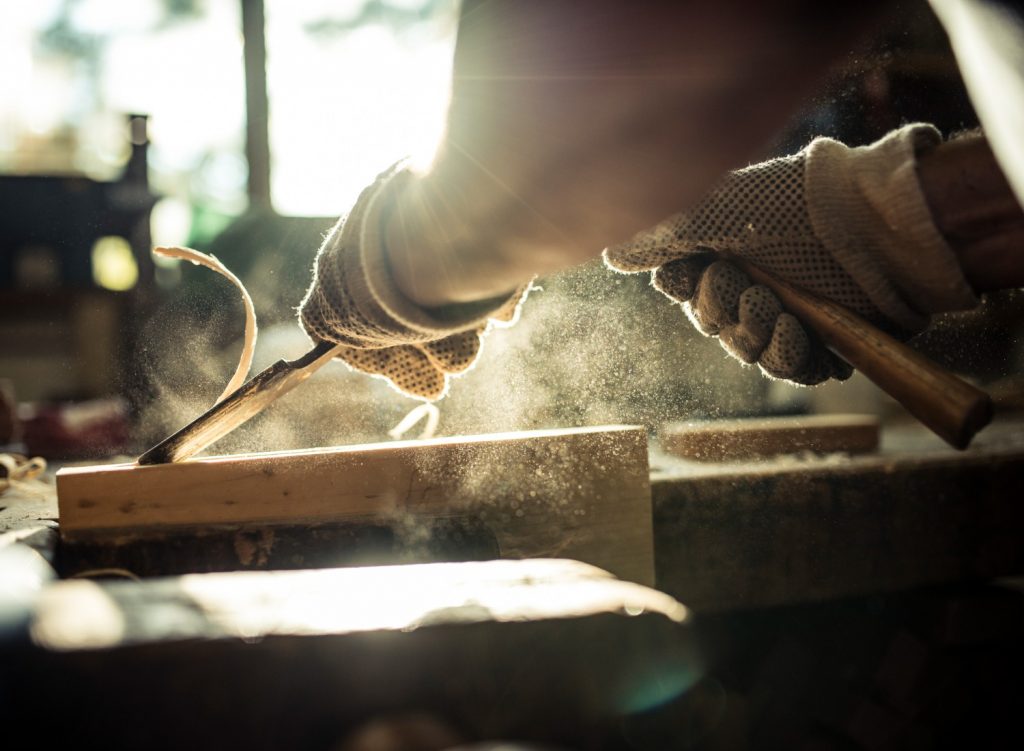 Man woodworking in a dusty woodshop