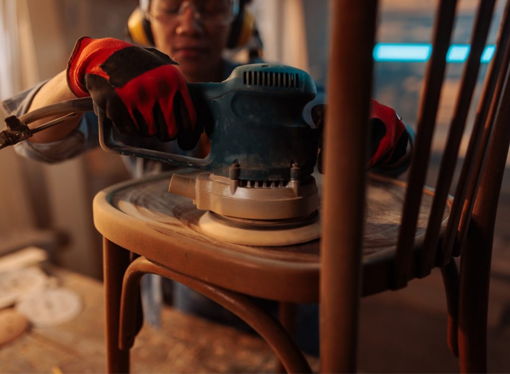 Woman sanding a wooden chair