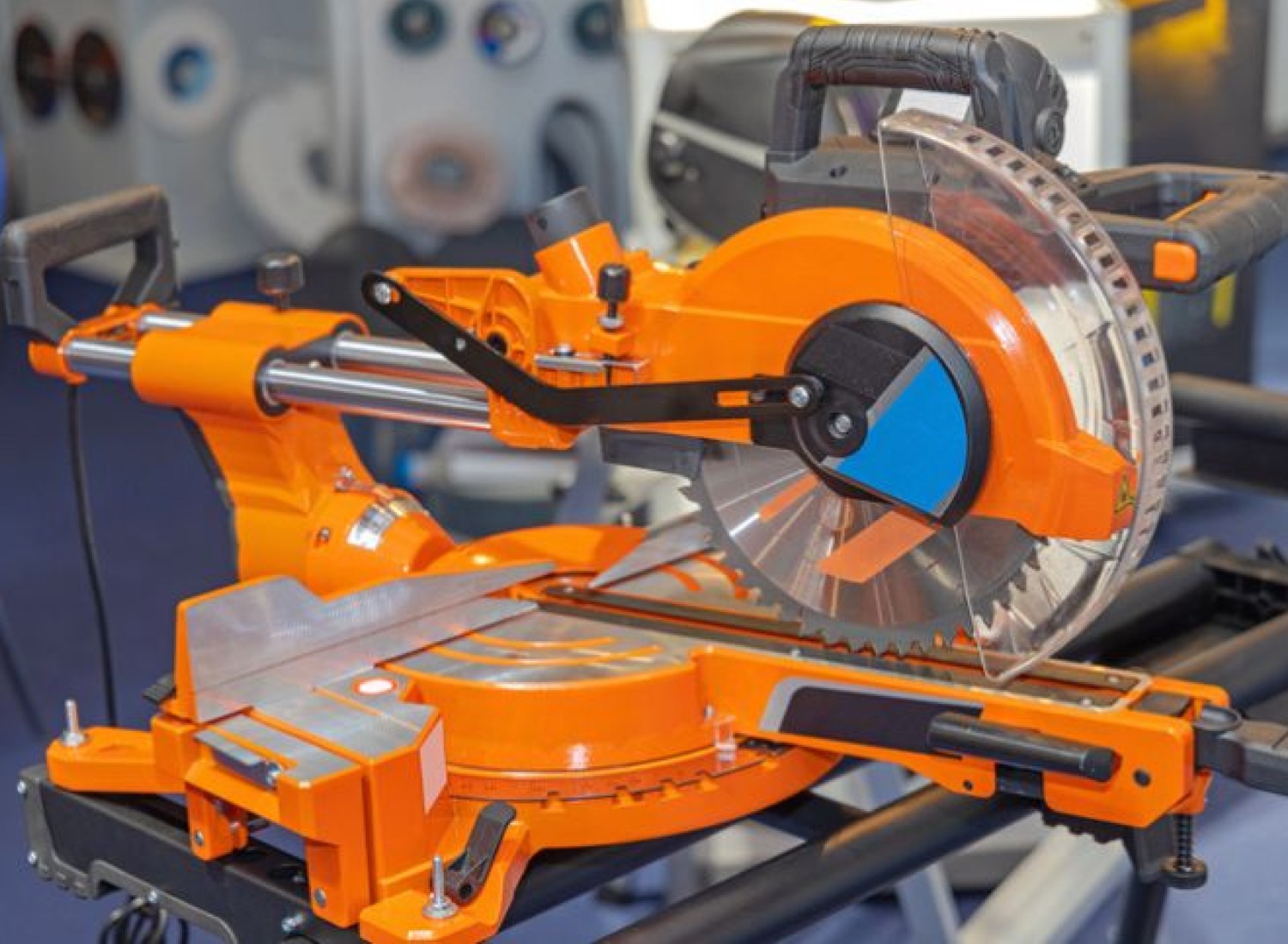 Image of an orange sliding miter saw in a shop.