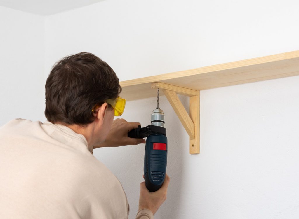 Man installing a wall shelf