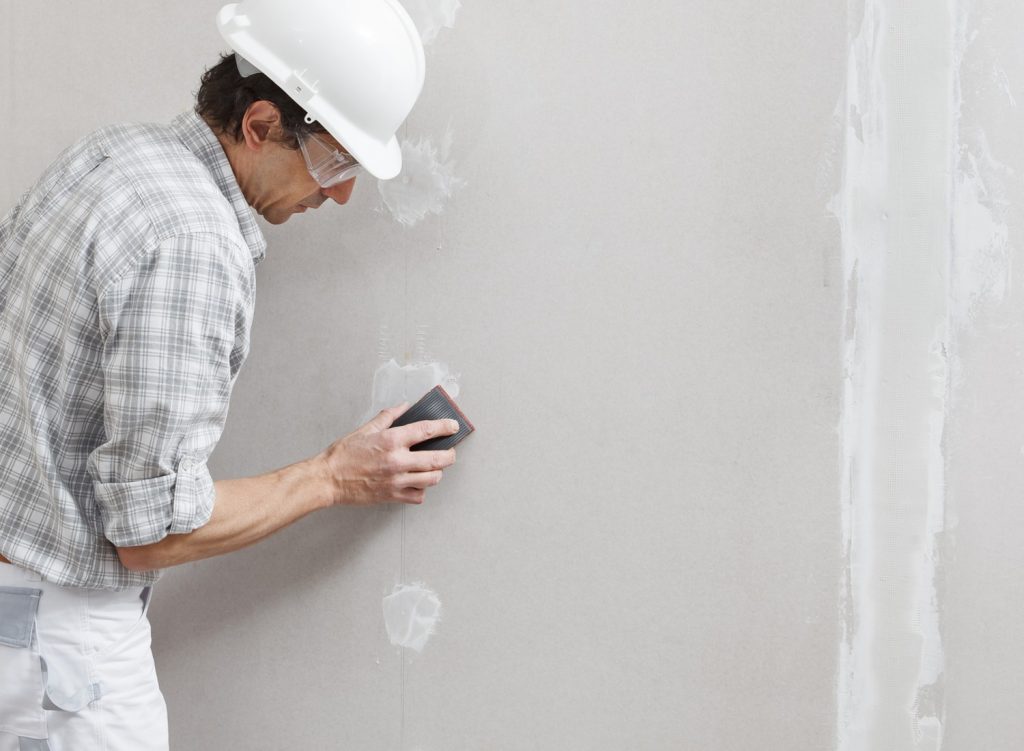 Man sanding drywall