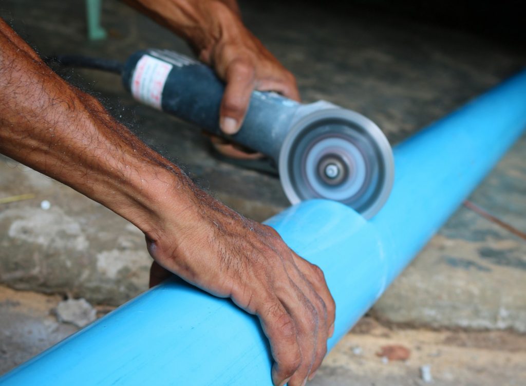 Man cutting PVC pipe with a circular saw